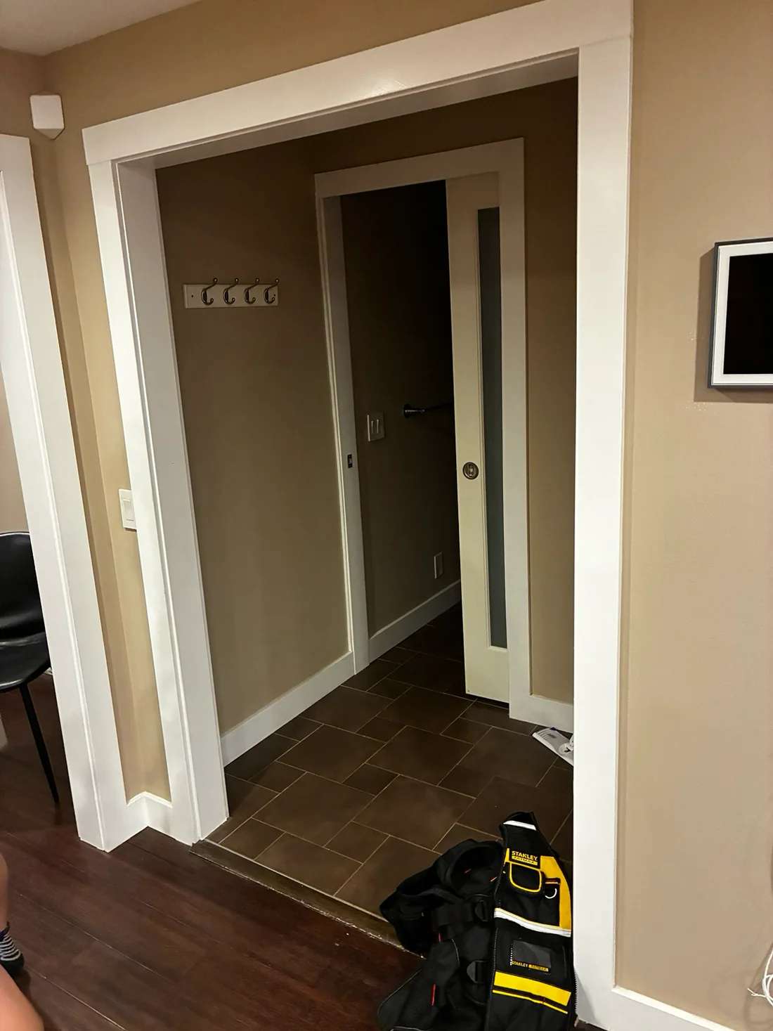 Entry hallway before: dark taupe walls with white-painted door casings and a white pocket door